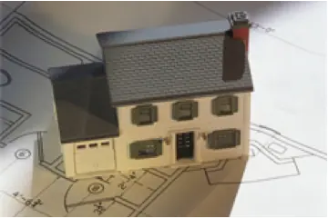 Photo of a toy house sitting on top of a set of plans