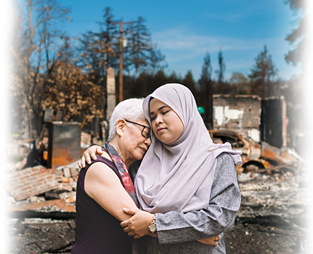 Two women comforting each other after a disaster.